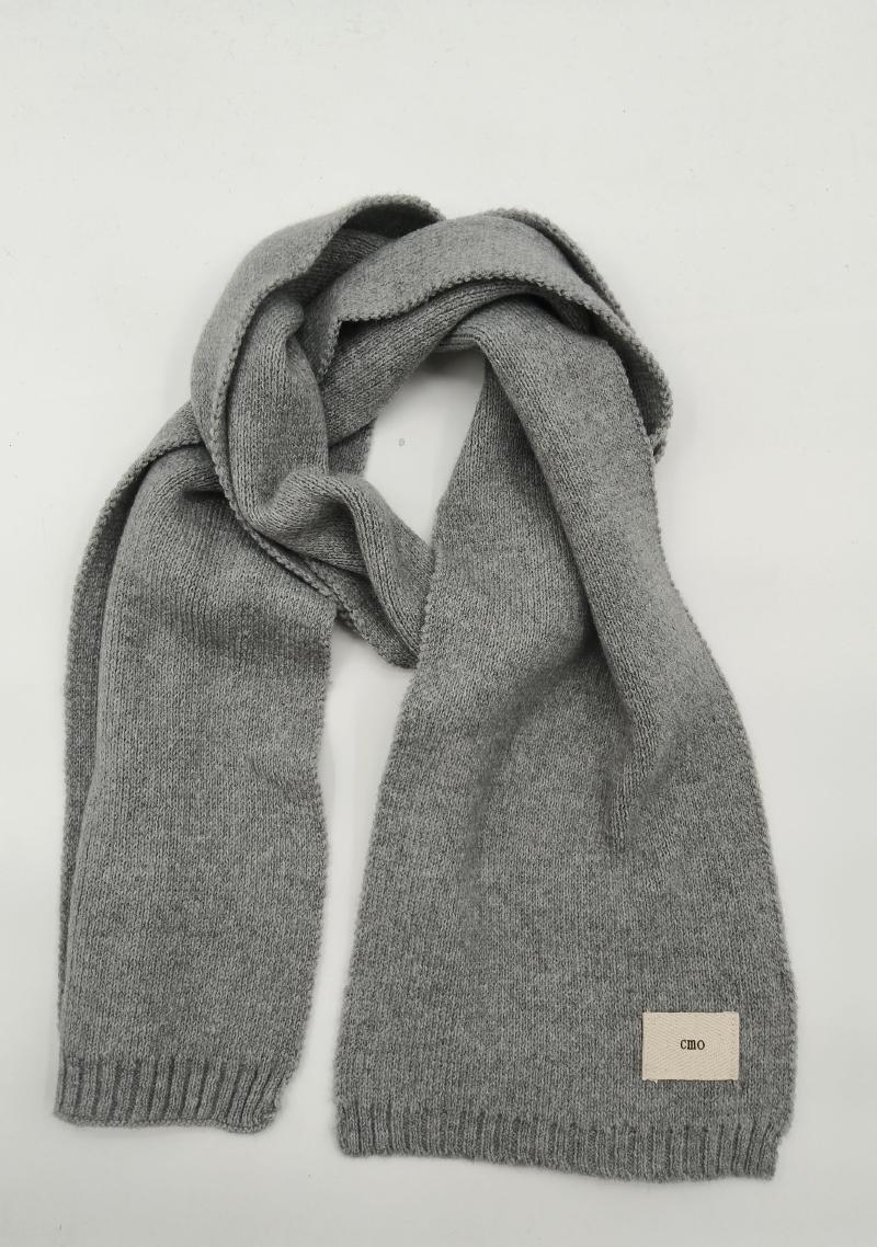 Heather grey knitted scarf with ribbed edges and woven label, loosely draped on white background