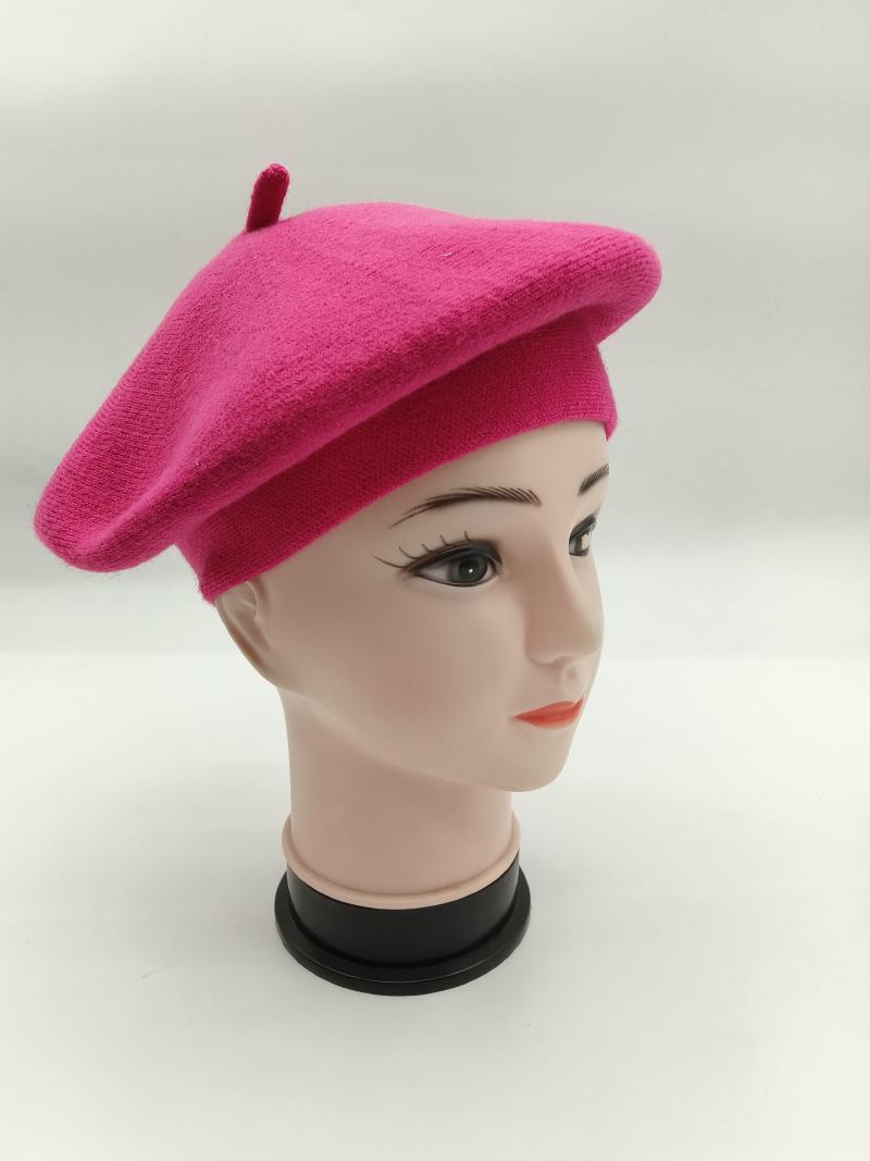 Hot pink wool knit French beret hat displayed on a mannequin head, side view showing classic round shape and center top button