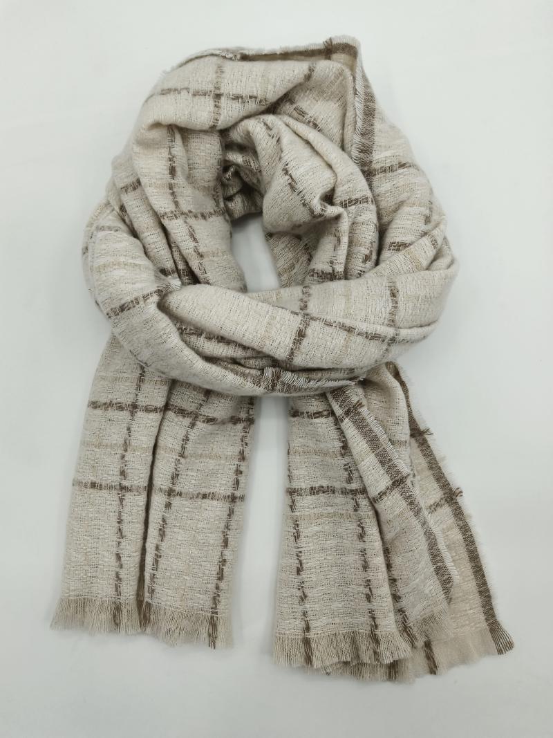 Lightweight ivory and brown plaid woven scarf with fringe edges, loosely wrapped and displayed on white background