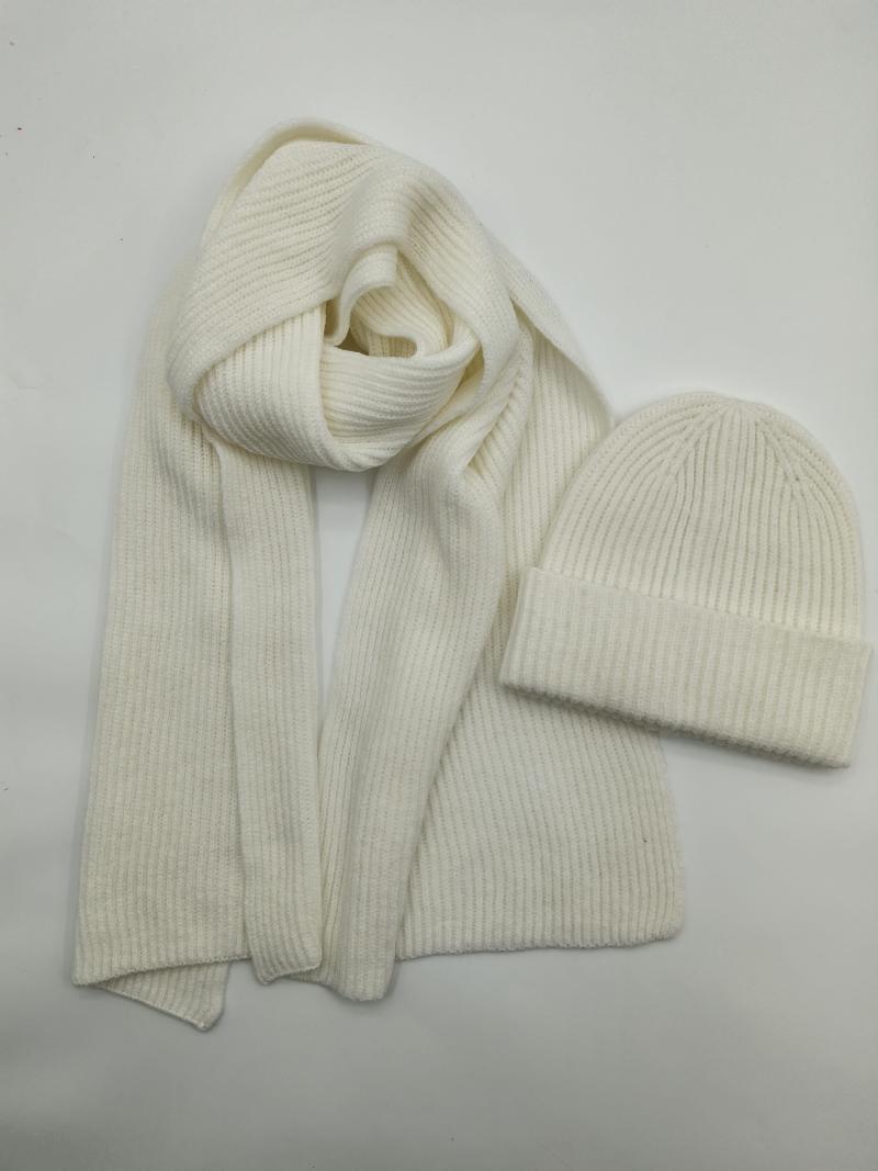 Cream ribbed knit winter scarf and matching beanie hat set laid flat on white background