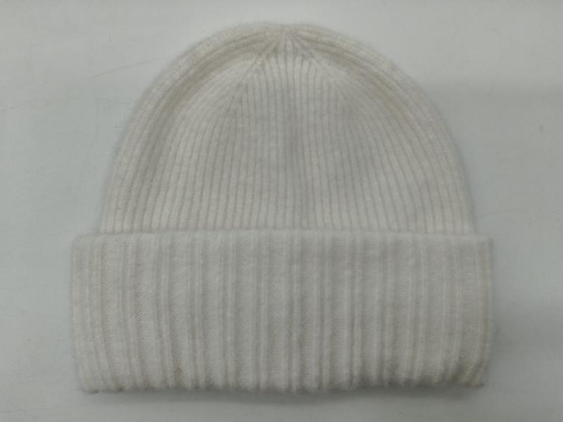 Cream white ribbed knit beanie hat with folded cuff laid flat on white background, soft wool blend winter hat