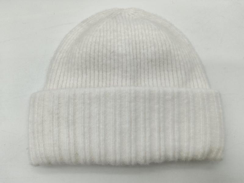 White ribbed knit winter beanie hat with folded cuff displayed flat on white background