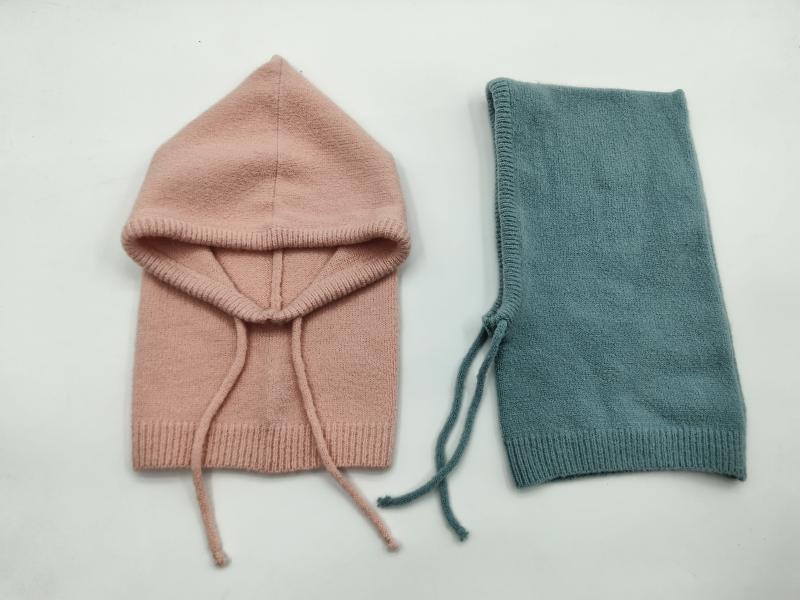 Two knit baby balaclavas laid flat, one blush pink with hood open and one folded teal, both with drawstring ties