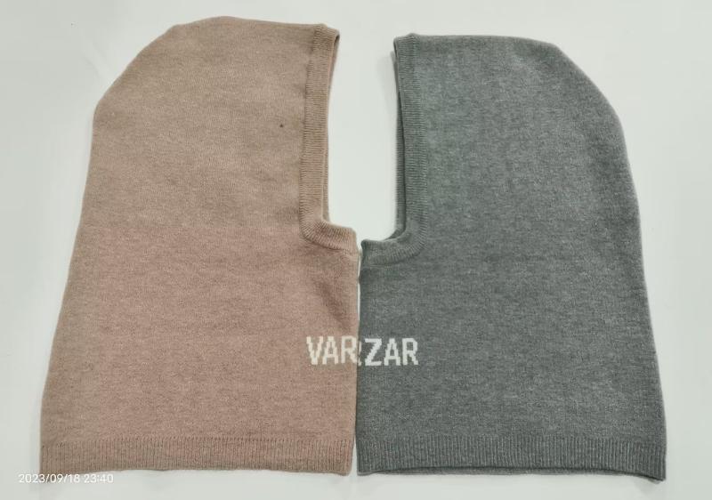 Two knitted balaclava ski masks laid flat, one in beige and one in grey, both with face opening and ribbed edges, branded VARIZAR