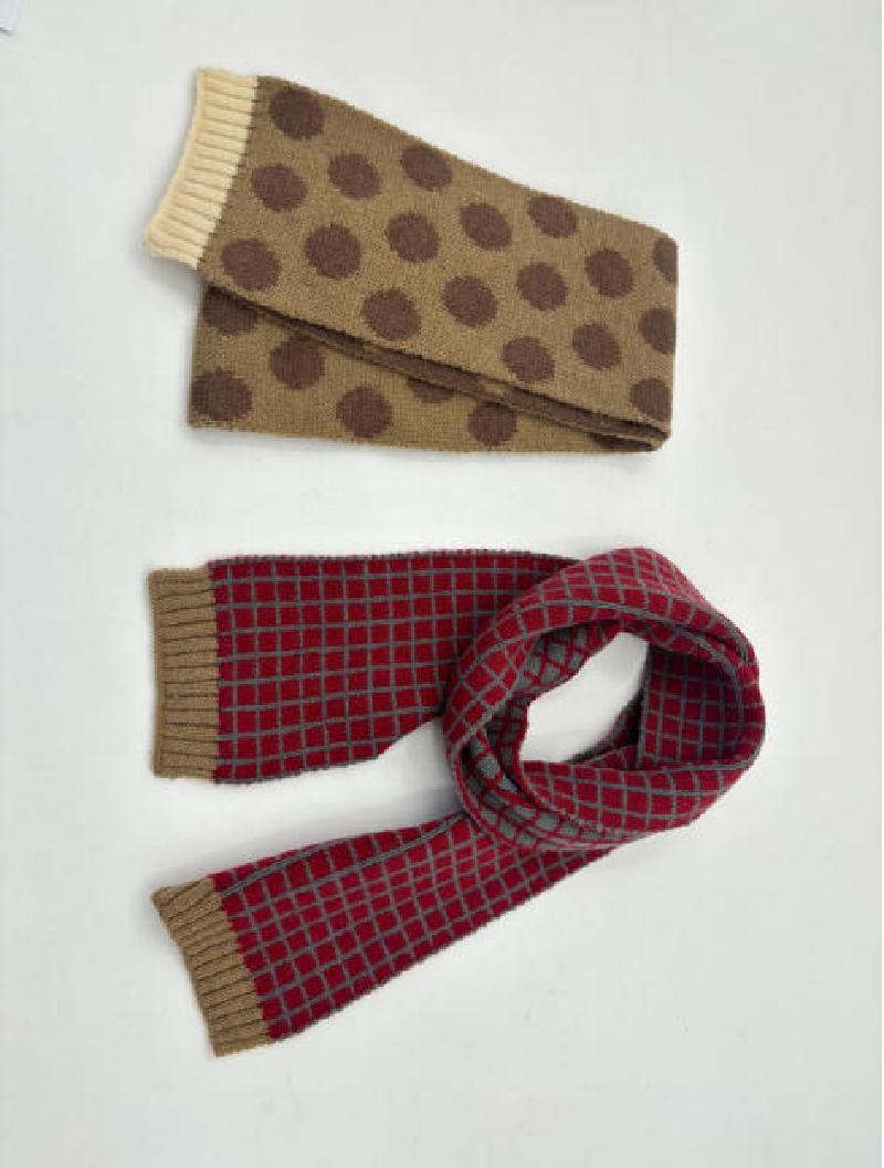 Two knit scarves flat lay: tan with brown polka dots and cream ribbed ends, red with gray grid pattern and khaki ribbed ends