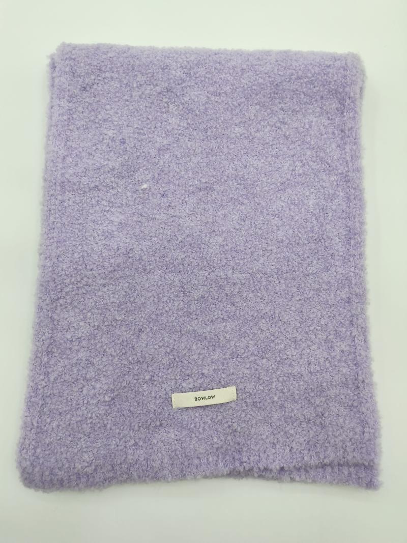 Folded lavender purple boucle texture soft throw blanket with small label on white background
