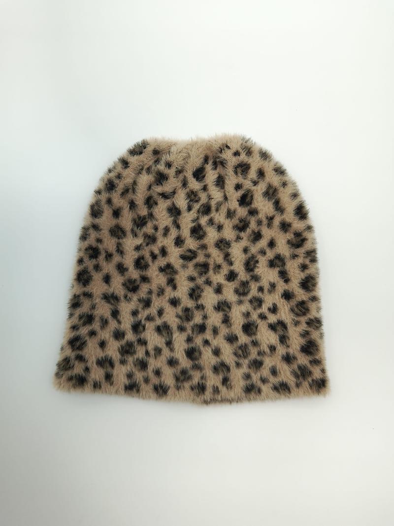 Flat lay of a tan and dark brown leopard print fuzzy knit beanie hat on a white background