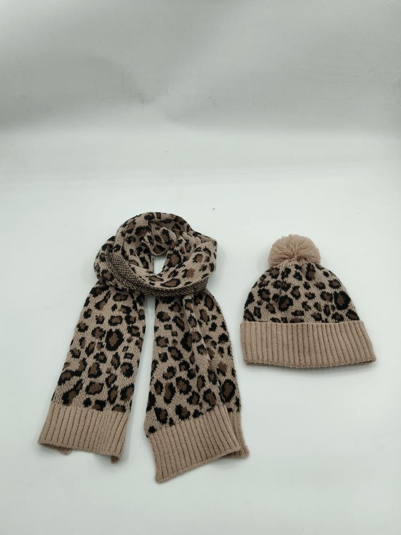Matching leopard print knit scarf and pom-pom beanie hat set in tan and brown animal print pattern