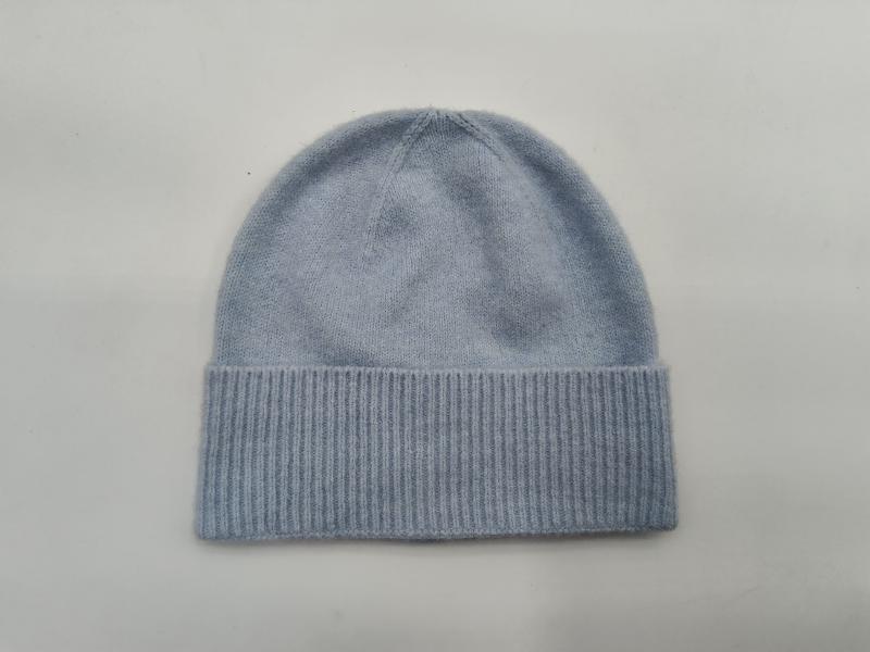 Light blue soft knit beanie hat with wide ribbed cuff, laid flat on white background, cashmere-style winter cap