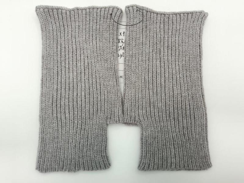 Pair of light gray ribbed knit fingerless gloves laid flat on white background, showing fine rib texture and open finger design