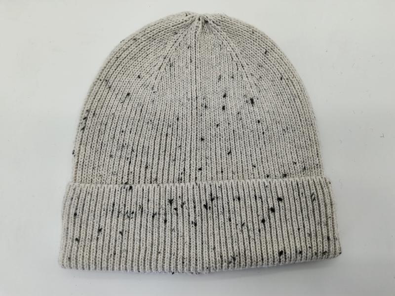 Light grey knit beanie hat with black speckle fleck pattern and folded ribbed cuff, laid flat on white background