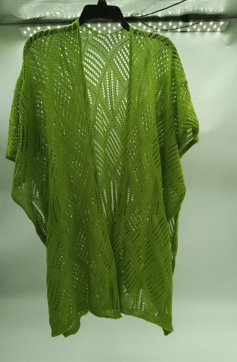 Lime green crochet lace kimono cardigan with diamond chevron pattern hanging on black hanger against white wall