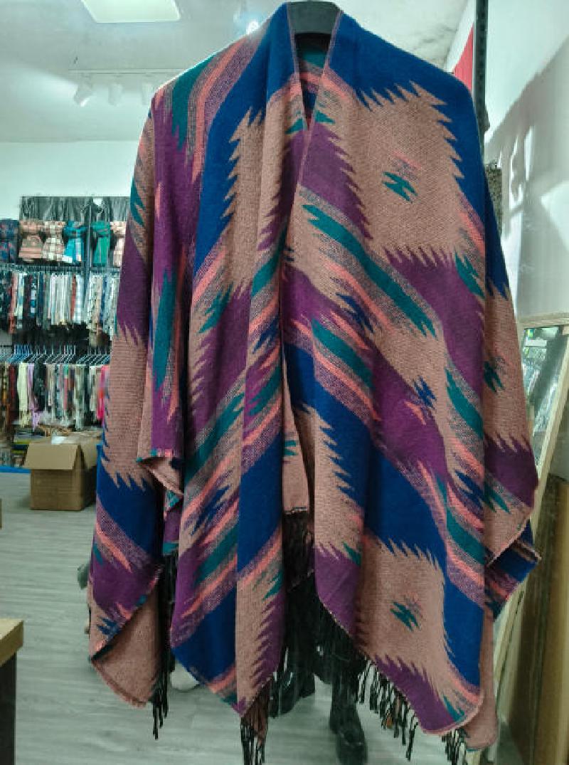 Oversized boho poncho wrap with zigzag Aztec pattern in blue, purple, teal and pink with black fringe hem