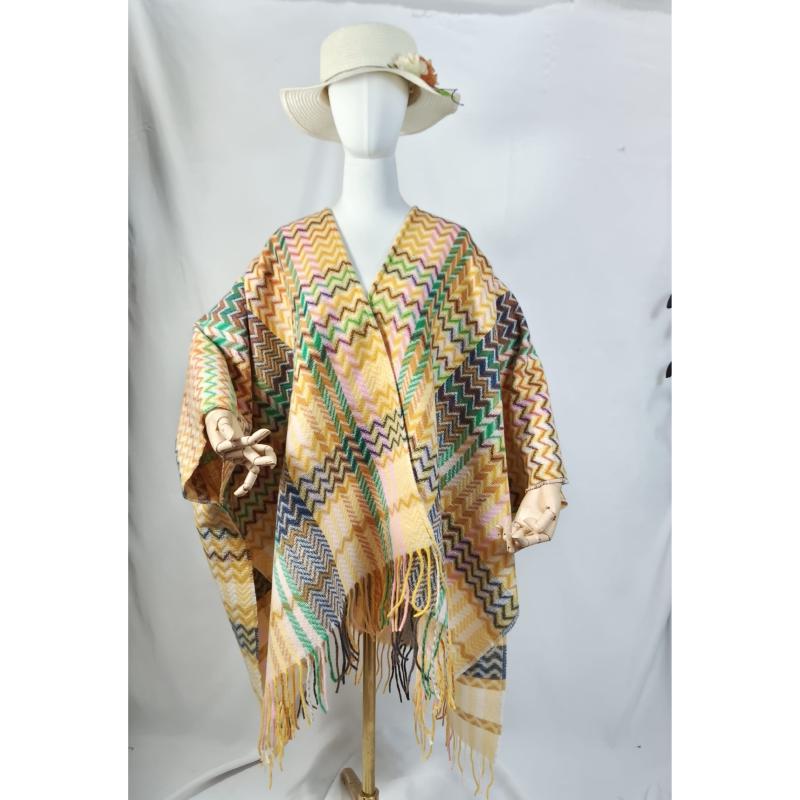 Mannequin wearing a multicolor chevron zigzag fringed poncho wrap with cream sun hat, displayed on white background