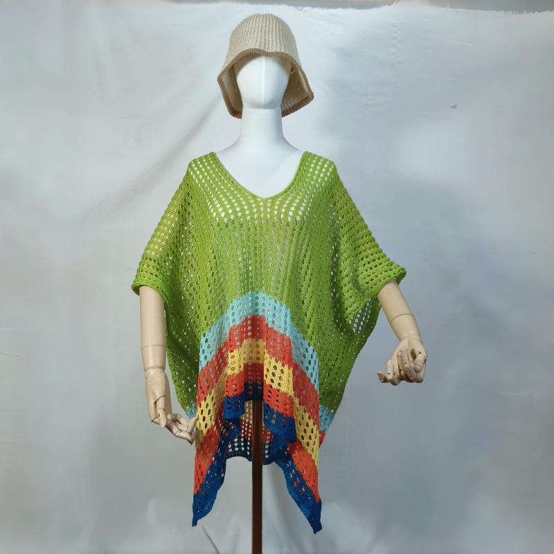 Mannequin wearing green crochet open-knit poncho with rainbow chevron hem and beige bucket hat, beach cover-up