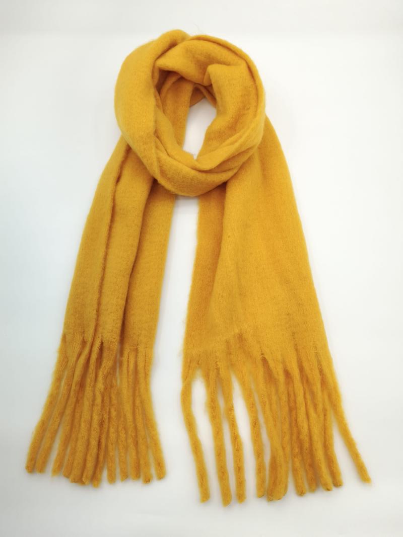 Mustard yellow soft fringed scarf looped and laid flat on white background, showing long tassel ends
