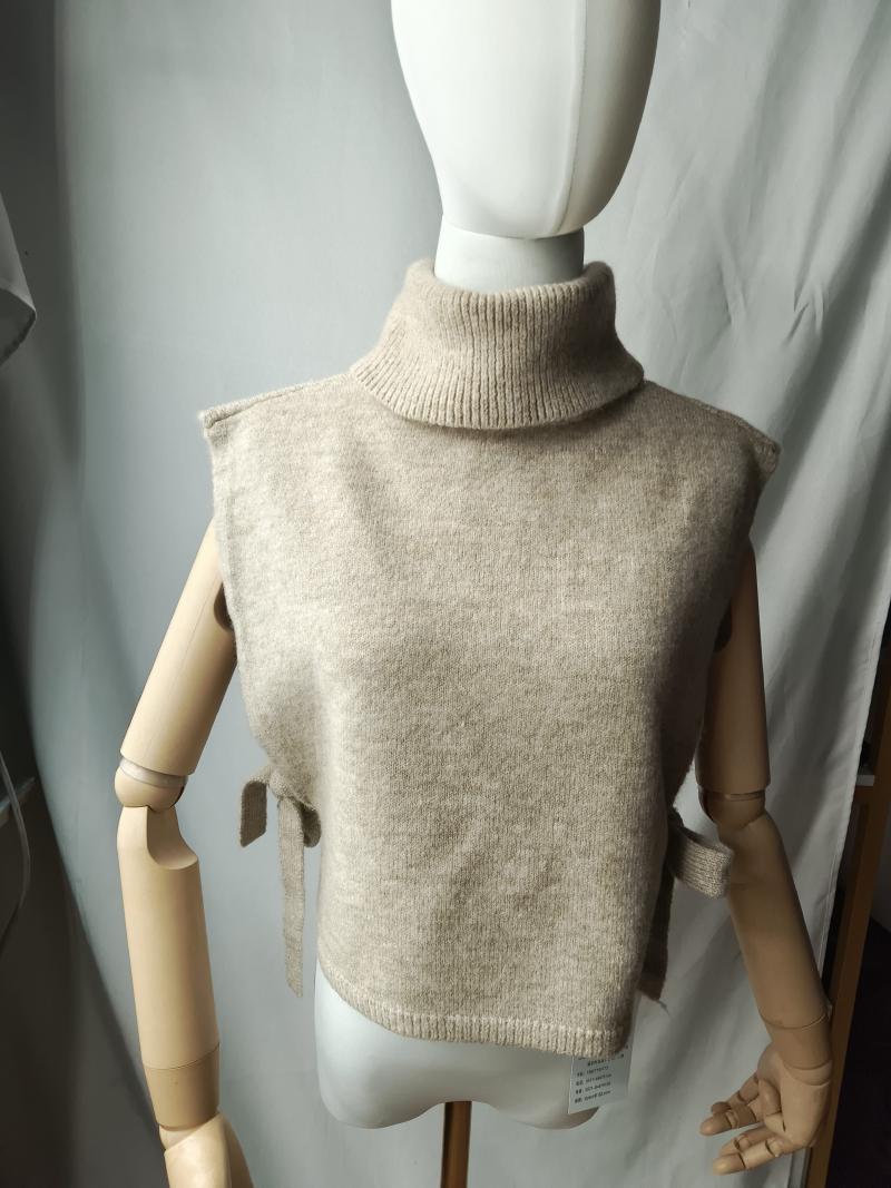 Beige sleeveless turtleneck knit sweater vest with side tie details displayed on a dress mannequin