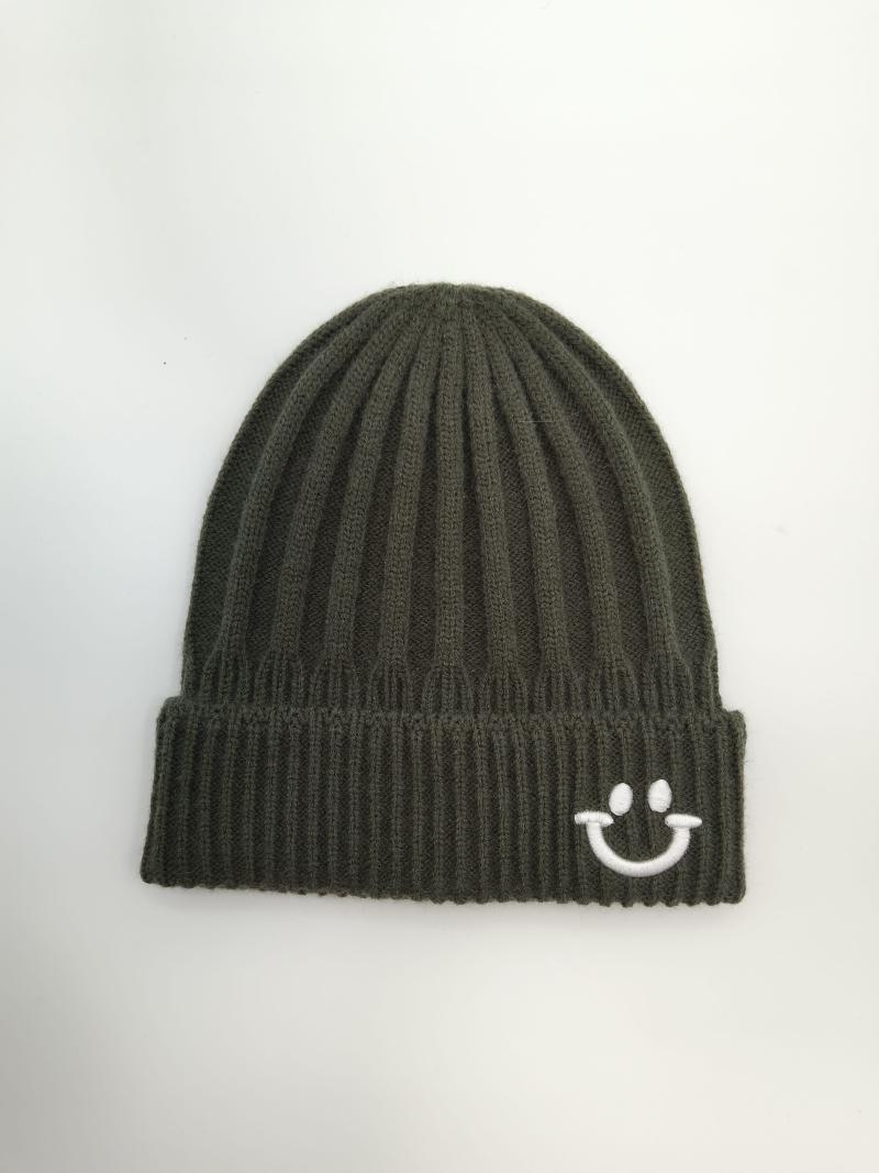 Olive green ribbed knit cuffed beanie hat with white embroidered smiley face on folded brim, laid flat on white background