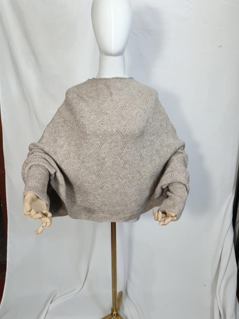 Oversized oatmeal beige pointelle knit batwing sweater displayed on mannequin with wooden hand props, back view